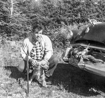 A black-and-white hunting photo of the author's dad with his car and grouse he'd shot in 1957.