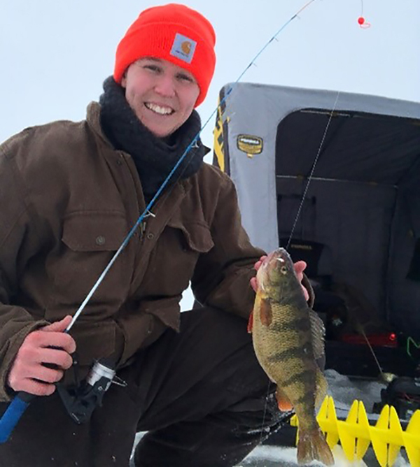 DNR park interpreter Katie Urban holding perch on frozen lake