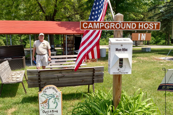 campground host sign with host in background