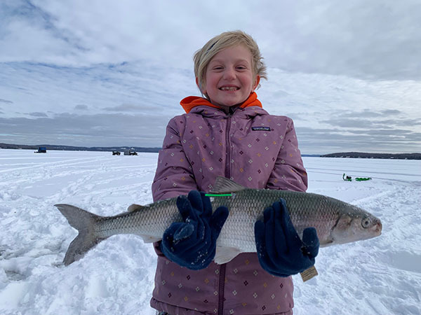 Child angler holding a tagged cisco