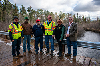 A group of local officials meet for a celebratory photo and a look at the new Black River bridge in October 2021.