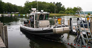 A scene shows a DNR patrol boat. This is a video button to click to see the short video on conservation officers.