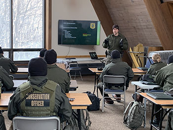 Conservation officers are shown in a classroom instruction session at the training academy.