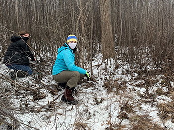 Two female stewardship volunteers in snowy forest