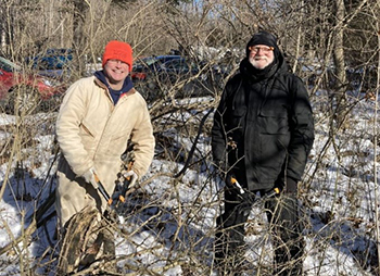 Two male volunteers holding hedge clippers for cutting brush