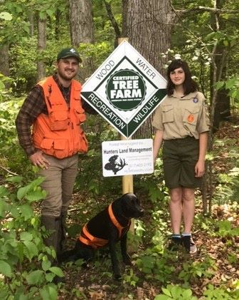 Hunter Fodor and Scout Amaya Golovich, whom he mentored, enjoy the forest along with a friendly dog. 