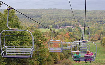 An early autumn photo shows two park visitors on the ski lift at Porcupine Mountains.