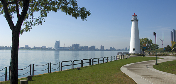 lighthouse along Detroit River with city skyline in background