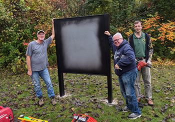 Workers install an interpretive sign frame along the Mike Levine Lakelands Trail.