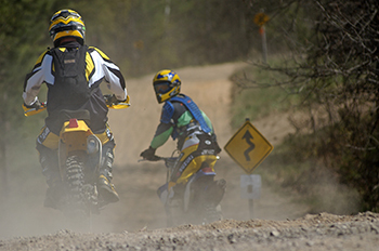 two motorcycles riding dirt trail