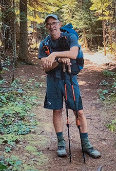 Dewey Painter is shown standing in hiking gear on the trail ready for hiking.