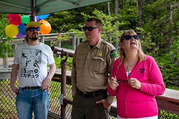 A group of three people use special glasses to correct colorblindness at the Porcupine Mountains.