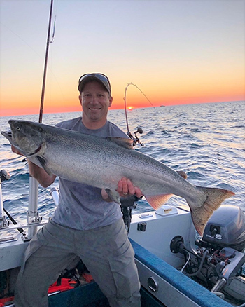 Angler holding a Chinook salmon in Lake Michigan