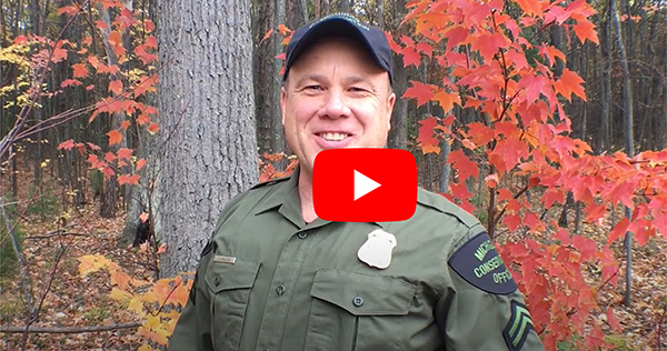 still frame of conservation officer talking in tree stand safety video with play button