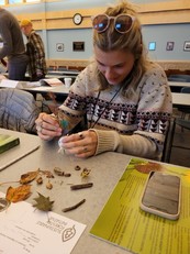A woman works on a craft activity during a PLT nature workshop. 