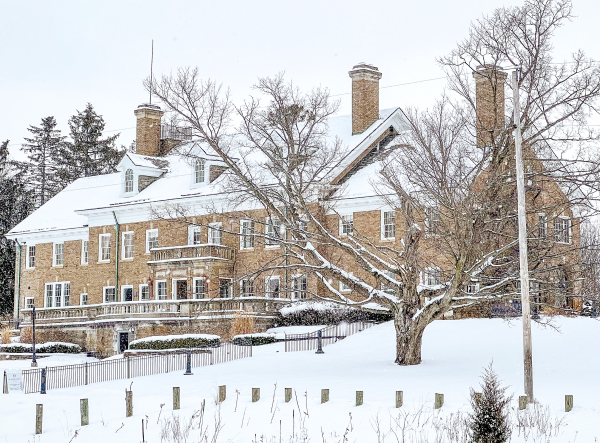 A large brick mansion blanketed with deep snow.