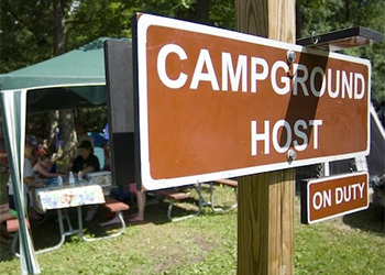 campground host sign with activity in background