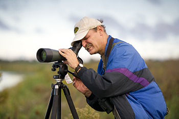 A birder adjust his spotting scope while on an outing in the Lower Peninsula.