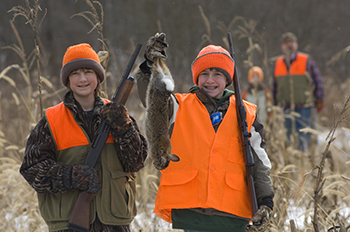 Two young rabbit hunters hold up the prize they shot that day.