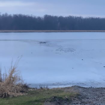 A hole in the ice of Blanch Lake where two people fell through