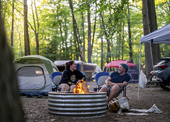 two campers sitting at fire