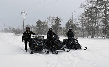 Michigan DNR conservation officers stop for a photo while on trail patrol.