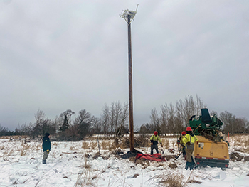 A pole with an osprey nesting platform is erected in Delta County.