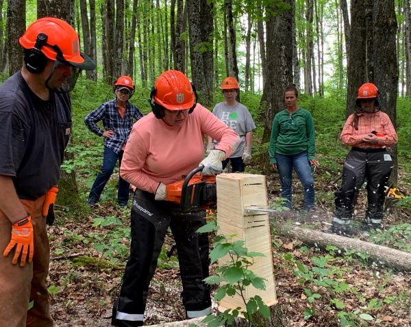Brock VanOss instructs a Women Owning Woodlands class in proper chainsaw techniques.