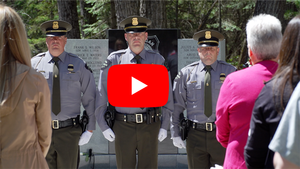 three officers stand during a ceremony