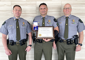 three men standing with an award