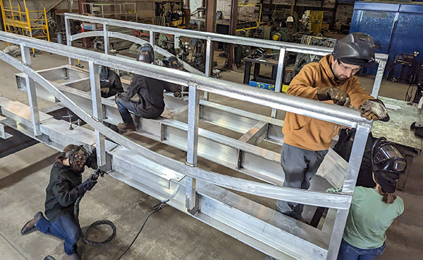 student welders and fabricators work on metal footbridge