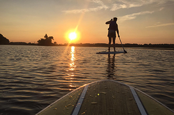 two stand-up paddleboarders on water
