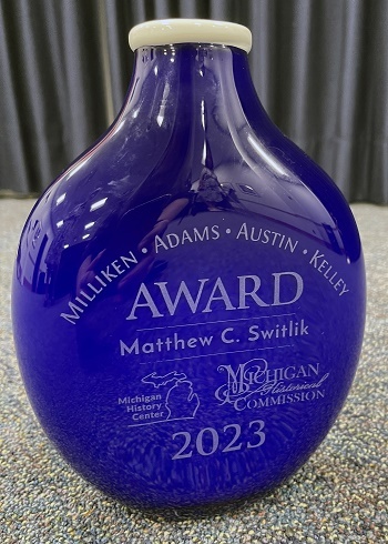 a blown-glass, cobalt-blue vase with a circular base and etched names Milliken, Adams, Austin and Kelley, plus award winner Matthew C. Sitlik