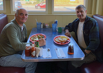 Heimo Korth, left and Al Dubord are shown sitting together in a restaurant.