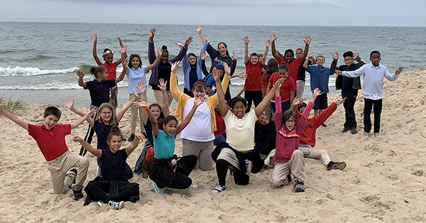 group of excited schoolchildren on Lake Michigan beach