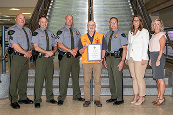 seven people pose in front of stairs