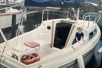 old photo of boat with dog and kid