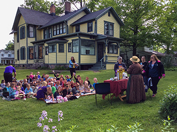 A modern-day tea ceremony is shown taking place on the lawn of the Mann House.
