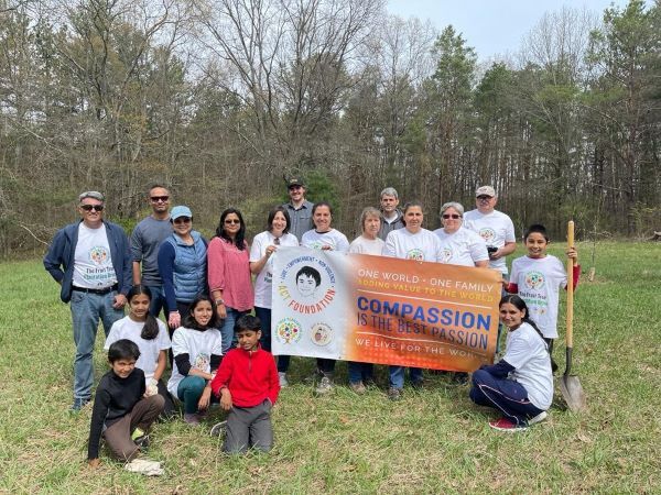 Volunteers who planted trees on the Allegan State Game Area smile for photo with the ACT Foundation's banner.