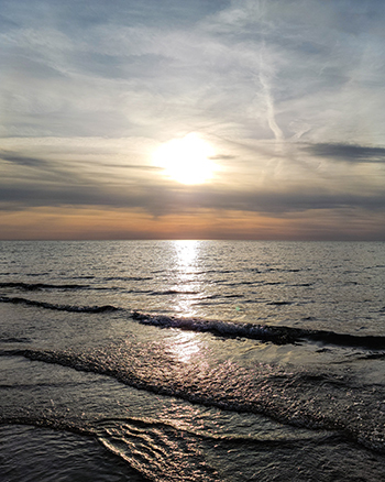 lapping water and sun behind hazy sky