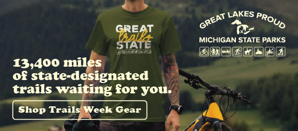 Shop Trails Week Gear; image of man with tattoos with Great Trails State T-shirt next to mountain bike