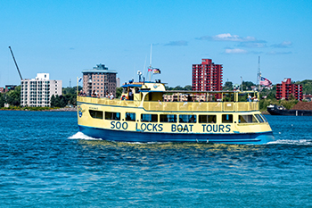 A Soo Locks boat tour boat heads upstream on the St. Marys River.