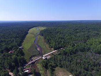 aerial view of Pigeon River flowing through forest at former dam site