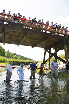 group cutting ribbon at site of dam removal