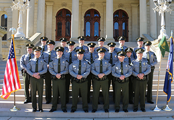 group of officers stand on steps outside smiling