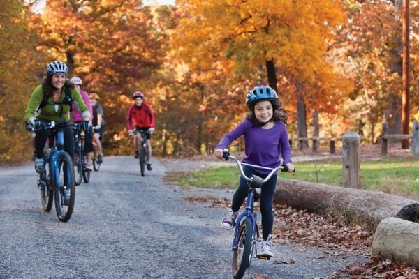 Family riding bikes on trail.