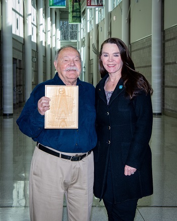 Awardee Don Inman, left, holds the NRC Washington Award plaque and is congratulated by Heidi Washington.