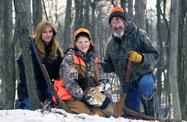 A successful hunter poses for a photo with her hunting mentors. 