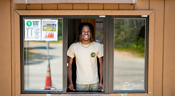 seasonal parker worker smiling in park contact booth