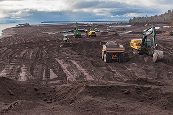 Crews work to remove stamp sands from the Lake Superior shoreline near Gay, Michigan.
